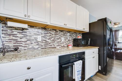 a kitchen with white cabinets and a black dishwasher at Dock and Furnished Deck Lakefront Gravois Mills Gem in Gravois Mills
