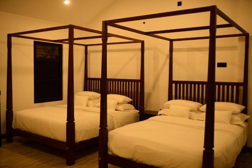 - deux lits à baldaquin dans une chambre dans l'établissement The Oceanfront Residence, à Ambalangoda