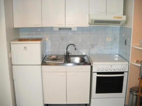 une cuisine avec un évier et un réfrigérateur blanc dans l'établissement Résidence L'accueil Sainte Germaine - Idéalement situé au centre ville d'Aix-les-Bains ! MAE-4264, à Aix-les-Bains