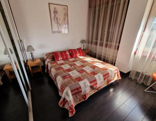 une chambre avec un lit avec des oreillers rouges dans l'établissement Résidence Les Belles Rives E - Magnifique et imprenable vue sur le Lac du Bourget ! MAE-6434, à Aix-les-Bains