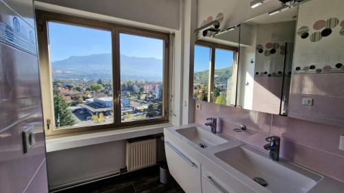 La salle de bains est pourvue de 2 lavabos et d'une grande fenêtre. dans l'établissement Résidence Les Belles Rives E - Magnifique et imprenable vue sur le Lac du Bourget ! MAE-6434, à Aix-les-Bains