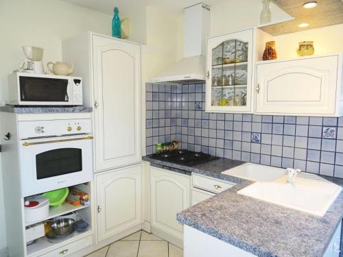 une cuisine avec des armoires blanches, un évier et un micro-ondes dans l'établissement Residence Aix Parc - Dans cadre verdoyant, logement paisible pour 4 personnes ! MAE-6454, à Aix-les-Bains