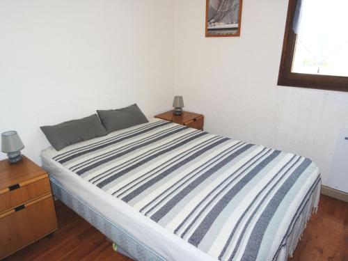 une chambre avec un lit avec une couverture rayée bleue et blanche dans l'établissement Residence L'alize - Au fil du lac - Entre Lac et Montagnes, charmant appartement ! MAE-6474, à Aix-les-Bains