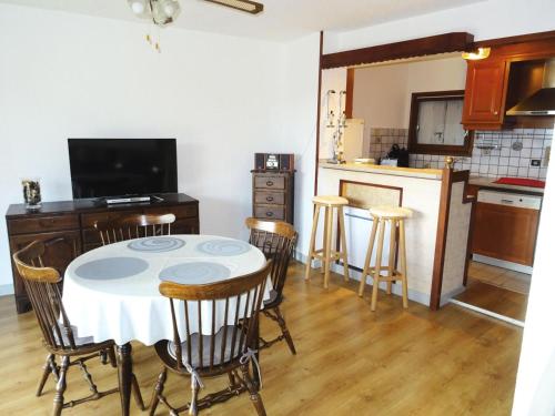 une cuisine avec une table et des chaises dans une pièce dans l'établissement Residence L'alize - Au fil du lac - Entre Lac et Montagnes, charmant appartement ! MAE-6474, à Aix-les-Bains