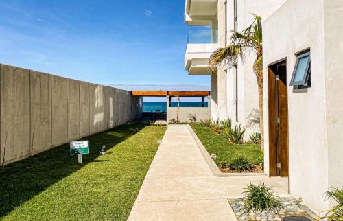 a backyard of a house with a grass yard at Luxury, Ocean View, Pool, Jacuzzi, Valle de Guadalupe, Los Portales De Garcia, Splash, Encanto Restaurants, Surf Breaks in Primo Tapia, Rosarito in Rosarito