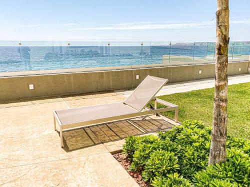 a chair sitting on a patio overlooking the ocean at Luxury, Ocean View, Pool, Jacuzzi, Valle de Guadalupe, Los Portales De Garcia, Splash, Encanto Restaurants, Surf Breaks in Primo Tapia, Rosarito in Rosarito