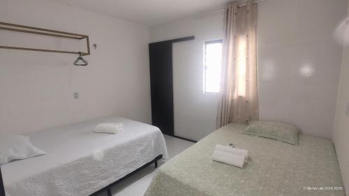 a bedroom with two beds and a window at Casa mobiliada de 2 suítes na R São Lázaro 2367 - 2370 - Jardim Gonzaga in Juazeiro do Norte