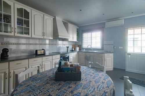a kitchen with white cabinets and a table in it at Peaceful Retreat in Mosteiros
