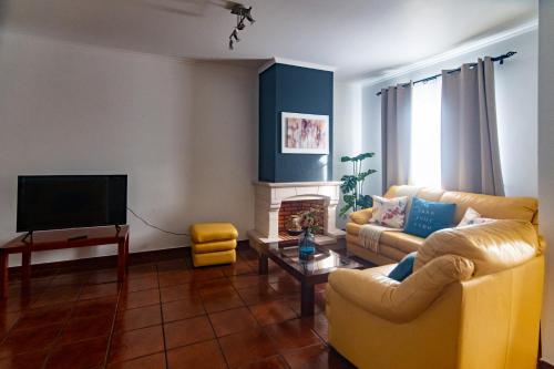 a living room with two couches and a television at Peaceful Retreat in Mosteiros