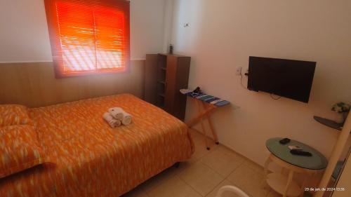 Schlafzimmer mit einem Bett und einem Flachbild-TV in der Unterkunft Casa mobiliada de 1 quarto na R Oliveira Alves Fontes, 597 - 597 A - Jardim Gonzaga in Juazeiro do Norte