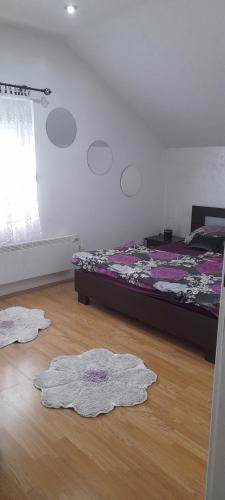 1 dormitorio con 1 cama y 2 alfombras en el suelo en Stan na dan -Bratunac-, en Bratunac