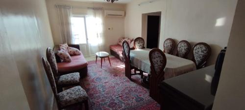 een woonkamer met stoelen en een tafel en een bank bij شقة مفروشة بمدينة الشروق in Madīnat ash Shurūq