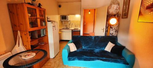 un salon avec un canapé bleu et une table dans l'établissement Lovely studio with balcony - near the beach, à Saint-Raphaël