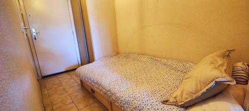 - une petite chambre avec un lit et une porte dans l'établissement Lovely studio with balcony - near the beach, à Saint-Raphaël