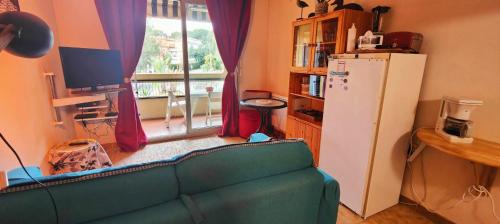- un salon avec un canapé et un réfrigérateur dans l'établissement Lovely studio with balcony - near the beach, à Saint-Raphaël