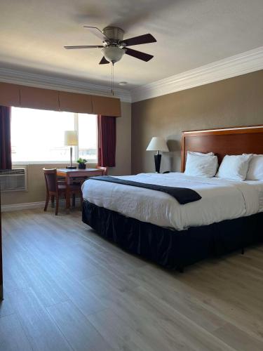 a bedroom with a large bed with a ceiling fan at Best Western Tradewinds in Morro Bay