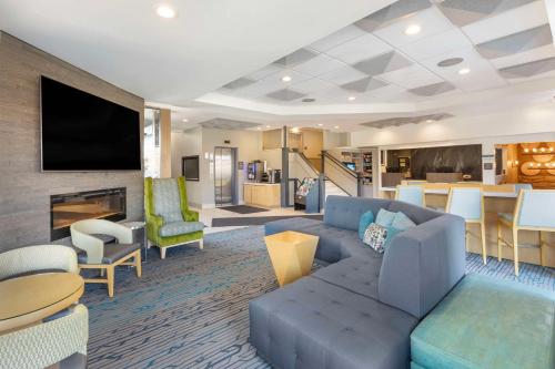 a living room with a blue couch and a table at Best Western Plus Milwaukee West in Milwaukee