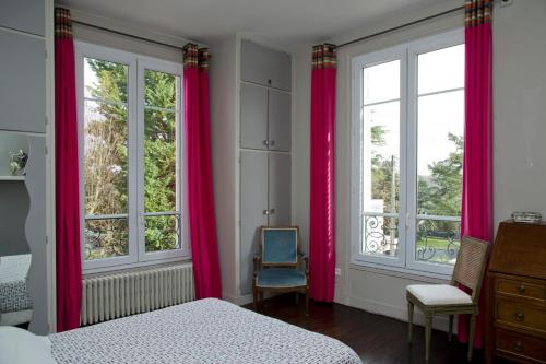 a bedroom with pink curtains and a bed and a chair at Home Sweet Home - Celle Saint Cloud Versailles in La Celle-Saint-Cloud
