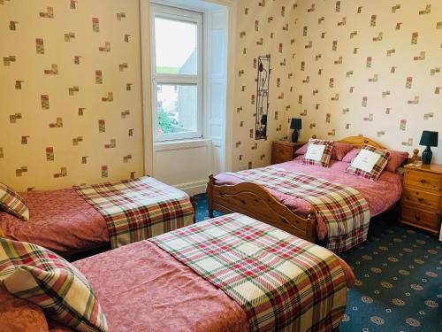 - une chambre avec 2 lits et une fenêtre dans l'établissement The Limes Guest House, à Montrose