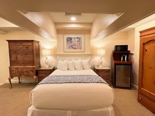 a bedroom with a large bed and a dresser at Best Western Grandma's Feather Bed in Mendenhaven