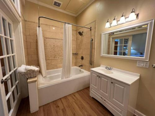 a bathroom with a tub and a sink and a shower at Best Western Grandma's Feather Bed in Mendenhaven
