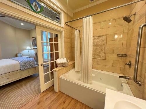 a bathroom with a tub and a bedroom with a bed at Best Western Grandma's Feather Bed in Mendenhaven