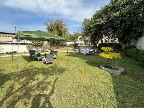 a group of chairs and a green canopy in a yard at Terraza del Lago in Tequesquitengo