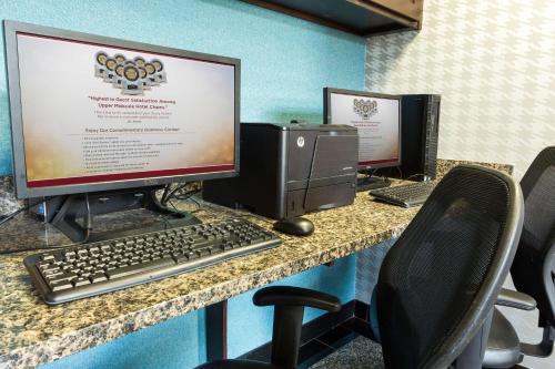 a desk with two computer monitors and a keyboard at Drury Inn & Suites Greensboro in Greensboro