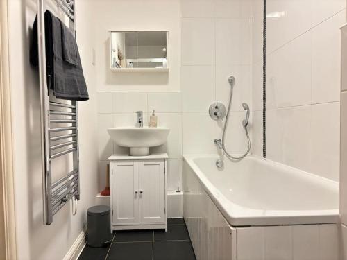 un bagno bianco con lavandino e vasca di Stunning apartment in Reading near City Centre & Train Station a Reading