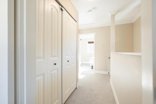 a white hallway with a closet and a door at Gondola Heights by Outpost Whistler in Whistler