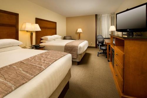 a hotel room with two beds and a flat screen tv at Drury Inn & Suites Springfield in Springfield