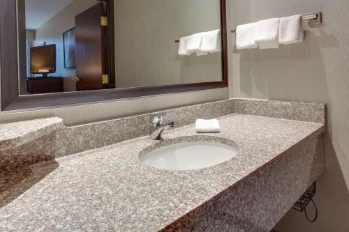 a bathroom with a sink and a mirror at Drury Inn & Suites Louisville East in Louisville