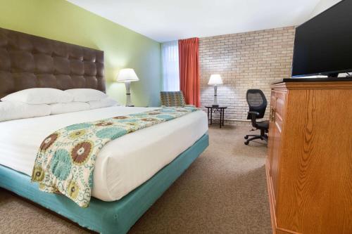 a hotel room with a bed and a flat screen tv at Drury Inn & Suites McAllen in McAllen