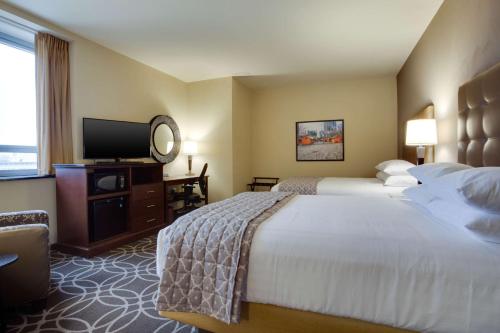 a hotel room with two beds and a flat screen tv at Drury Plaza Hotel Pittsburgh Downtown in Pittsburgh