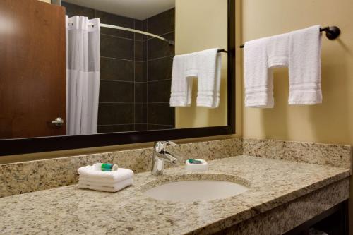 a bathroom with a sink and a mirror and towels at Drury Plaza Hotel Pittsburgh Downtown in Pittsburgh