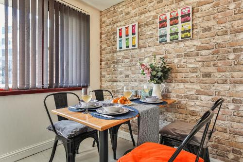 a dining room with a table and chairs and a brick wall at Noknokstay-GeorgeHouse -CityCentre-Sleep 8-FreeParking in Sheffield