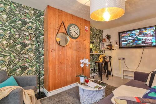 sala de estar con reloj en la pared de madera en NoknokStay - Sheffield city centre en Sheffield