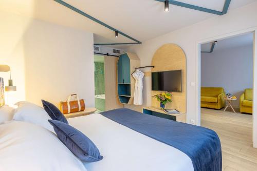 a bedroom with a large bed and a living room at Urban Hotel & Spa Aix-les-Bains - BW Signature Collection in Aix-les-Bains