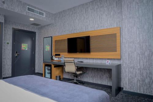 a bedroom with a desk and a television on a wall at Best Western Premier DJ Hotel in Djibouti