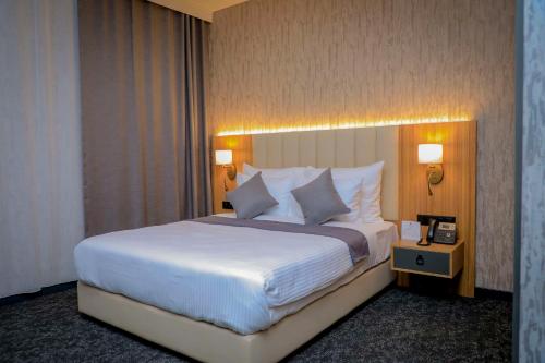 a bedroom with a large bed with white sheets and pillows at Best Western Premier DJ Hotel in Djibouti