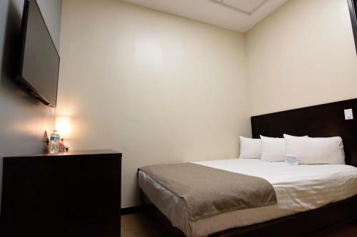 a bedroom with a bed and a flat screen tv at Hotel Dunas Near Consulate in Ciudad Juárez