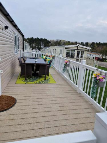 a wooden deck with a table on a house at flower pot retreat in Scarborough