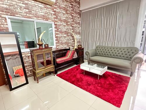 a living room with a couch and a red rug at ประกายทอง พูลวิลล่า 
