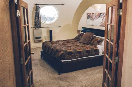 een slaapkamer met een bed en een raam bij Beautiful Dome in Crestone