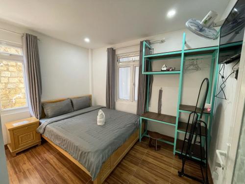a bedroom with a bed and a green shelf at Homestay BỒ CÔNG ANH in Da Lat