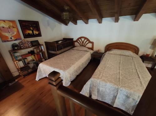 two beds in a room with wooden floors at Casa Maite in Ríoseco de Soria