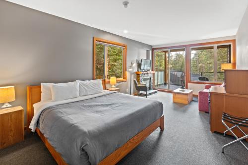 a bedroom with a bed and a living room at The Cabins at Terrace Beach in Ucluelet