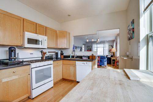 a kitchen with white appliances and wooden cabinets at Pet-Friendly Saint Paul Vacation Rental with Deck! in West Saint Paul