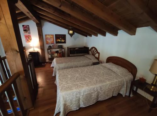 two beds in a room with wooden floors at Casa Maite in Ríoseco de Soria
