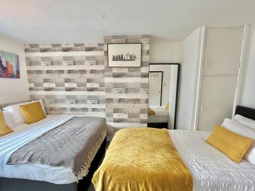 1 dormitorio con 2 camas y pared de madera en NoknokStay - Sheffield city centre en Sheffield